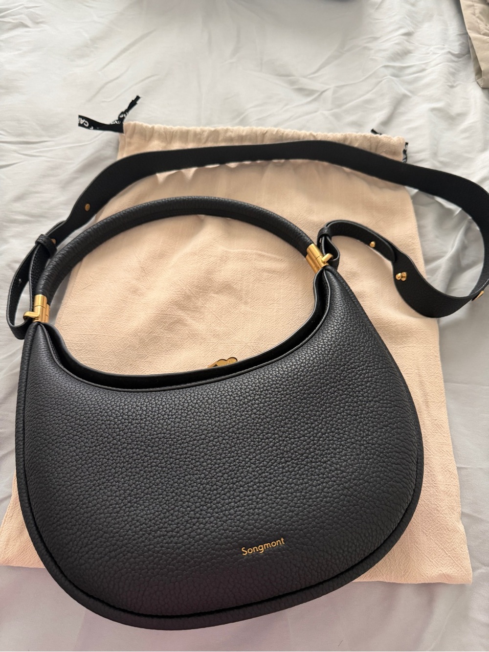 Songmont Black Pebbled Crescent Shoulder Bag with Gold Accents